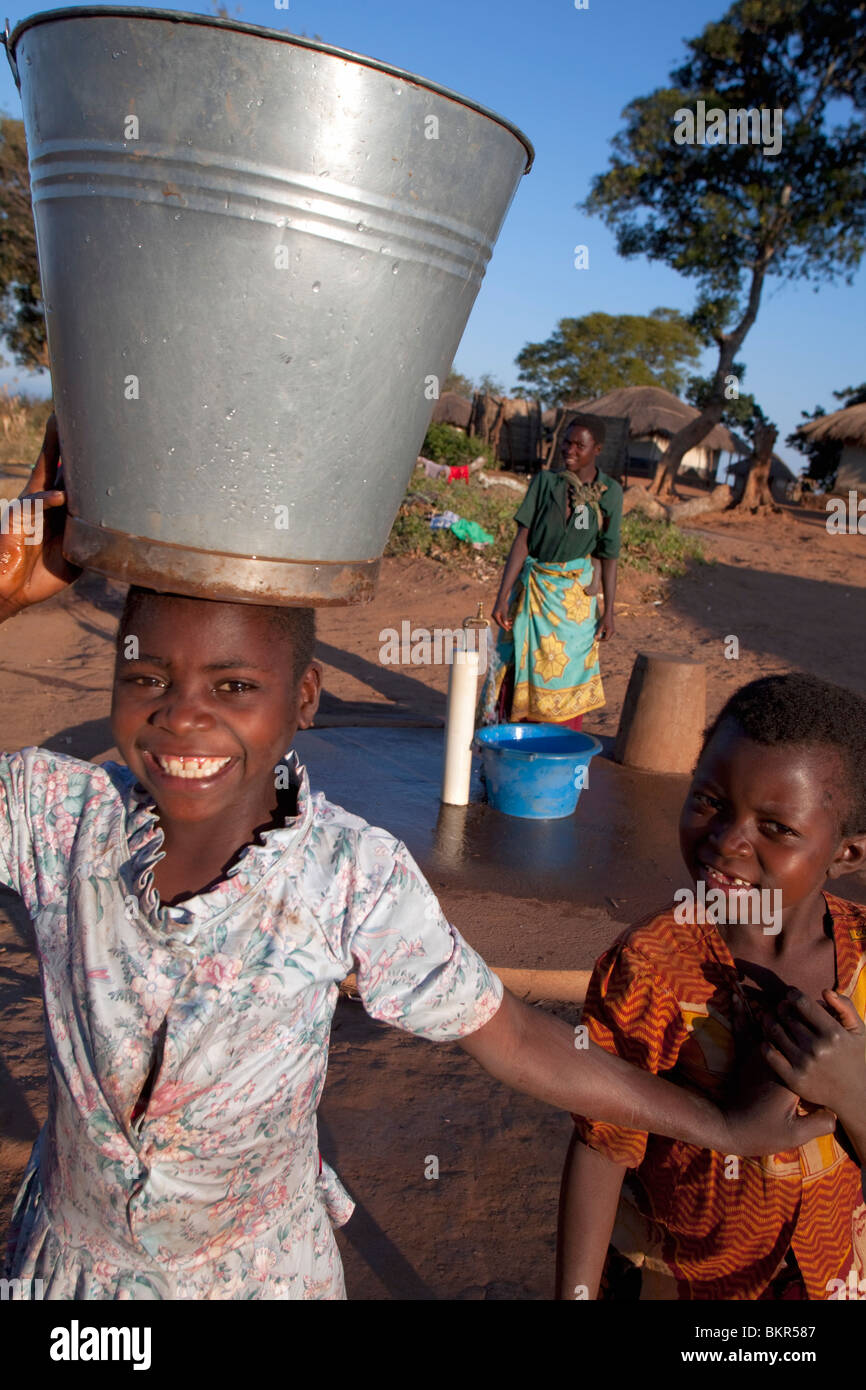 Le Malawi, Lilongwe, Ntchisi réserve forestière. Avec un approvisionnement en eau propre les villageois se réunissent pour recueillir de l'eau Banque D'Images