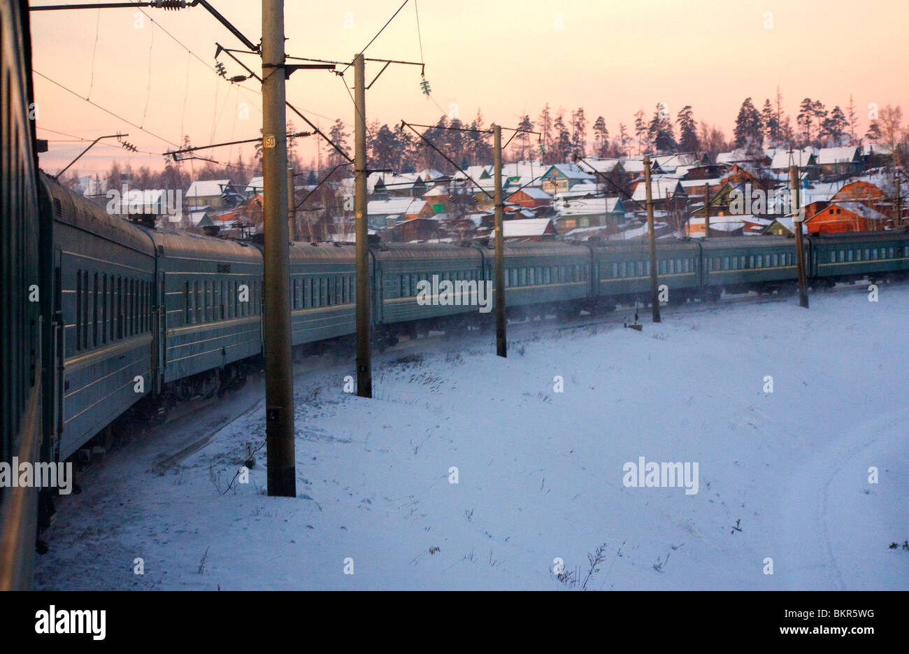 La Russie, la Sibérie, ; le train transsibérien prenant rapidement sur le sentier du transsibérien au milieu de la neige de Sibérie et des huttes Banque D'Images