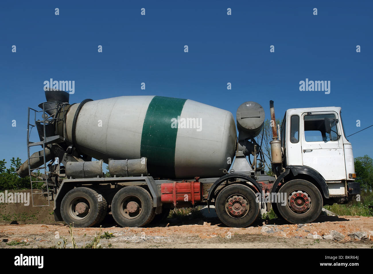 Camion malaxeur béton garé at construction site Banque D'Images