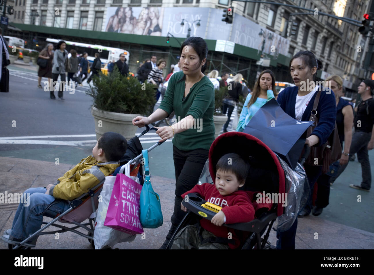 Les femmes asiatiques avec des enfants en poussette shop sur 34th Street à New York. Banque D'Images