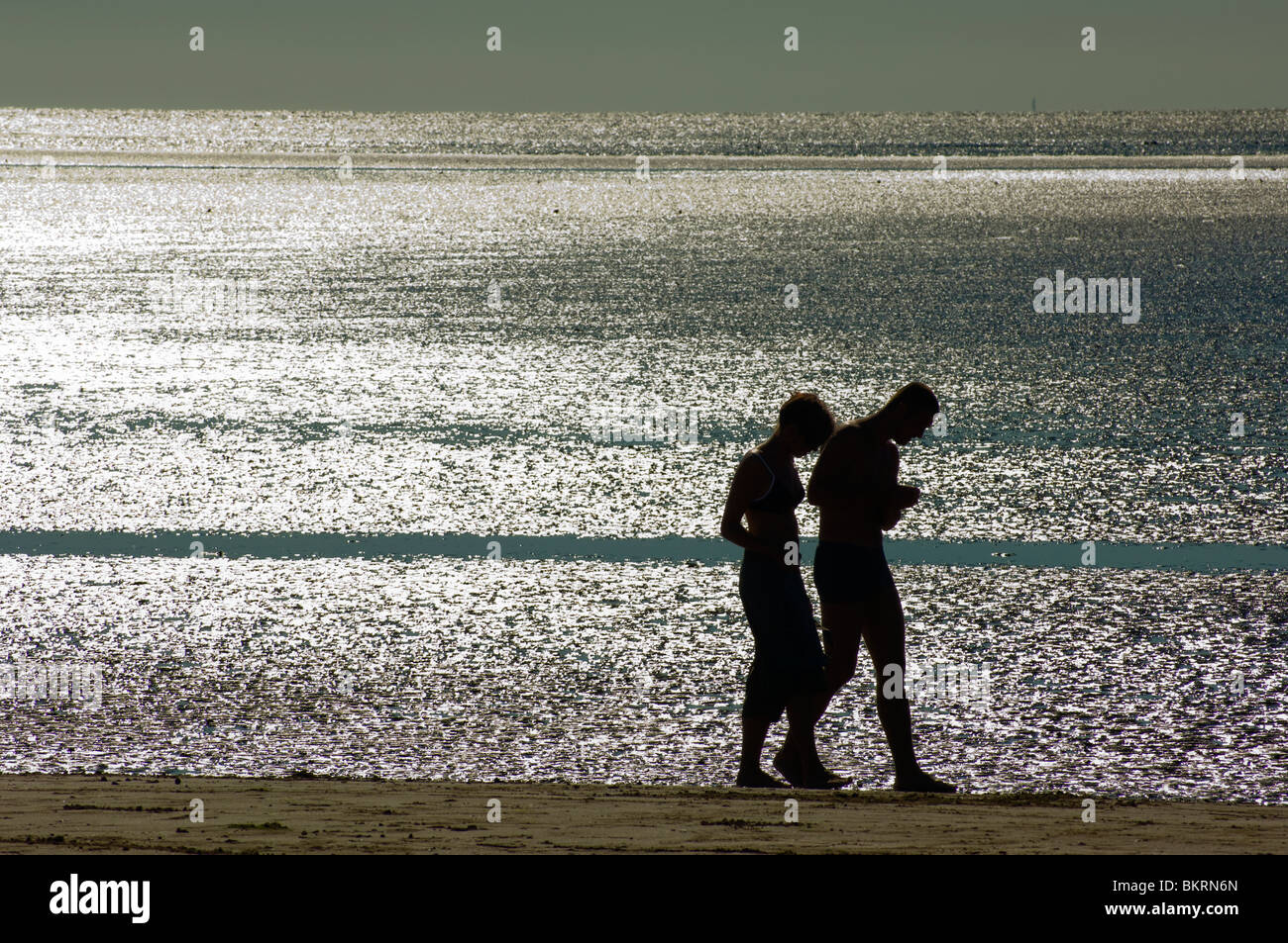 Couple en contre-jour sur la plage de Blackpool, Angleterre Banque D'Images