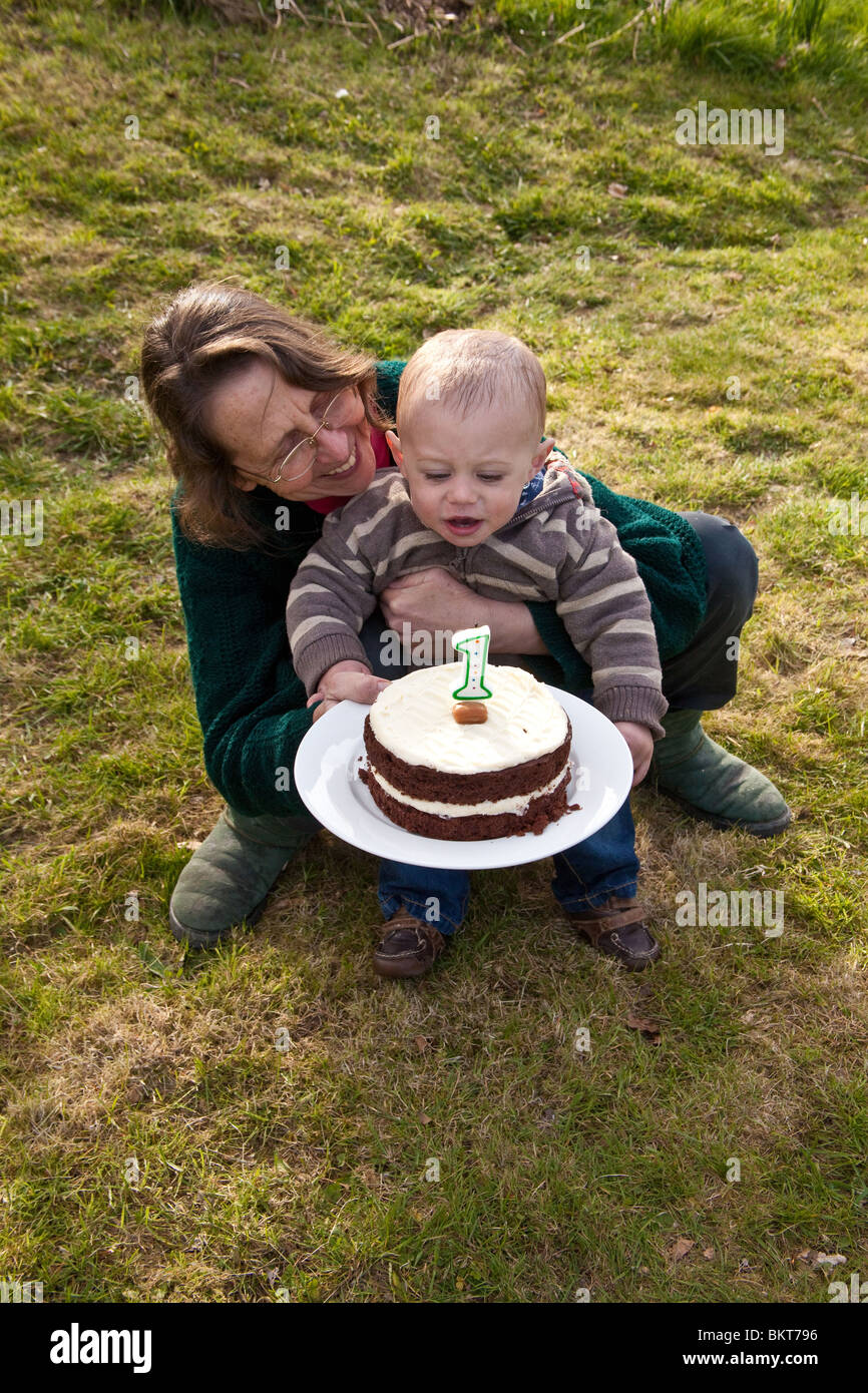 Bebe Garcon Age D Un An A L Exterieur Avec Son Gateau D Anniversaire Et Grand Mere Hampshire Angleterre Royaume Uni Photo Stock Alamy