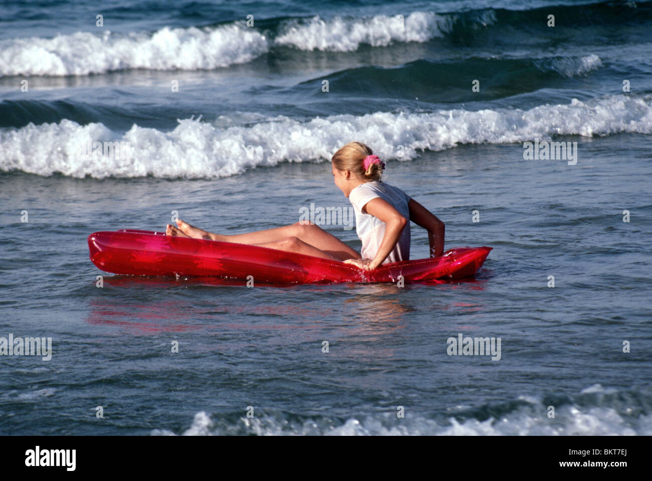 Enfant jouant avec lilo sur beach Banque D'Images