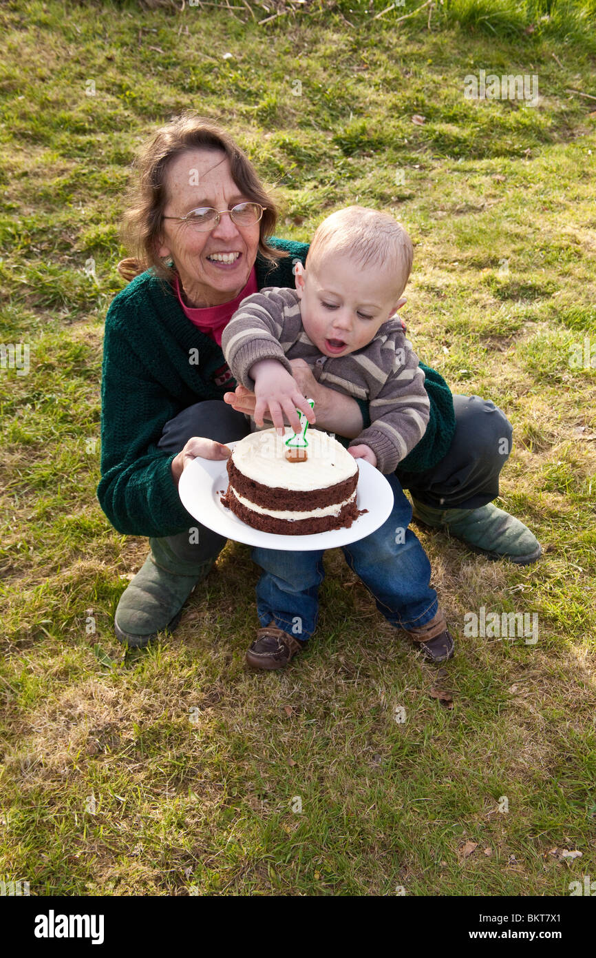 Bebe Garcon Age D Un An A L Exterieur Avec Son Gateau D Anniversaire Et Grand Mere Hampshire Angleterre Royaume Uni Photo Stock Alamy