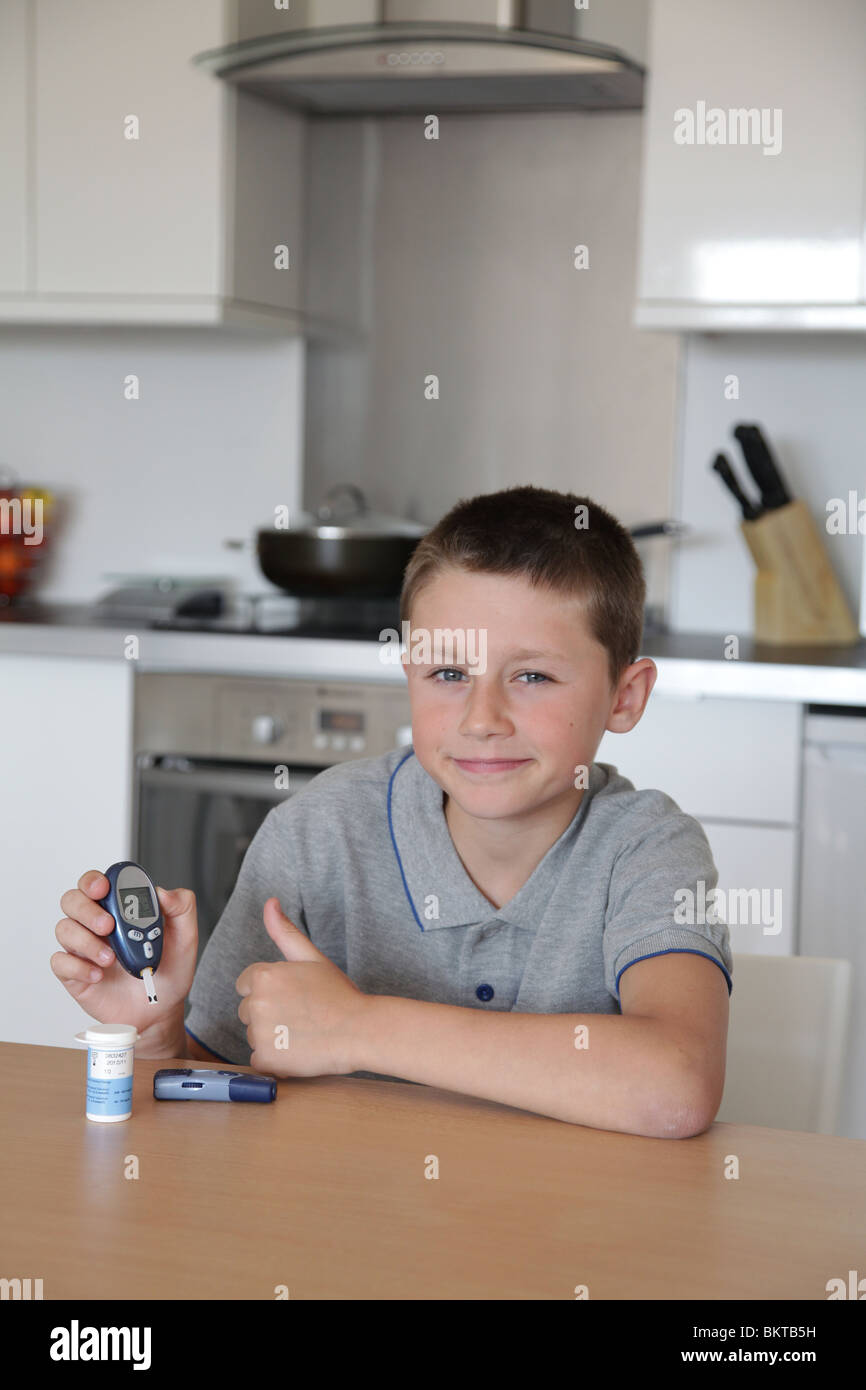 Jeune garçon qui montre les résultats de test de glycémie - Diabète Banque D'Images