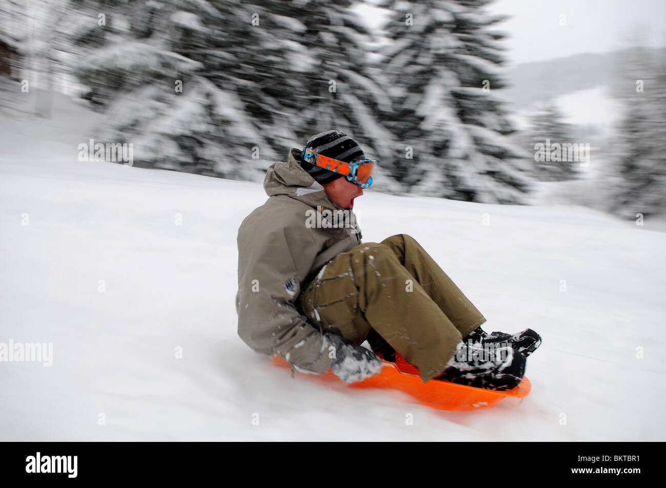 Un homme traîneaux en bas d'une pente à la vitesse en français station de ski de Courchevel 1650. Banque D'Images