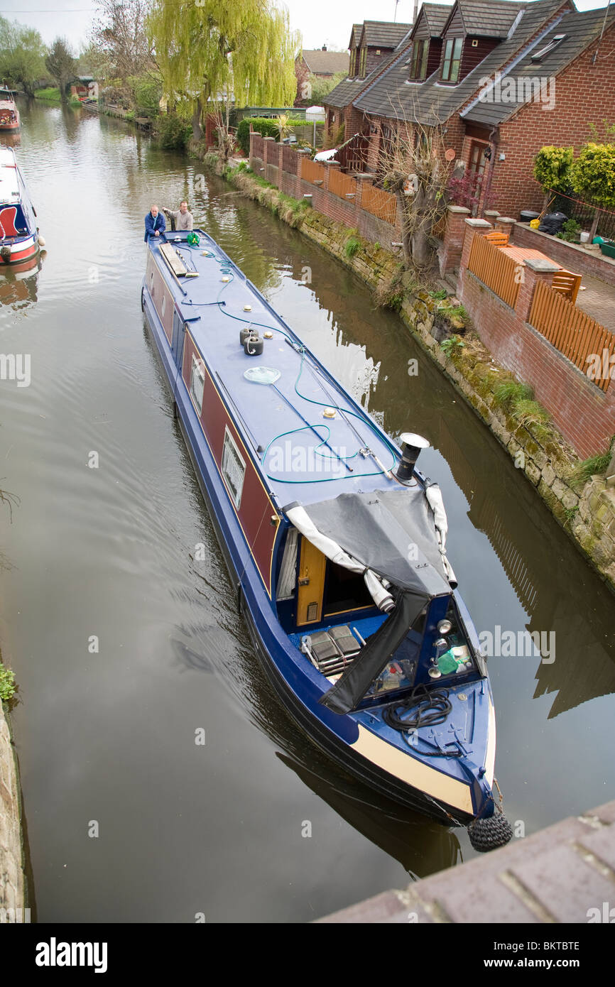 Un étroit canal boat sur le point de passer sous un pont sur le Canal Grand Union, Loughborough, Leicestershire, Angleterre. Banque D'Images