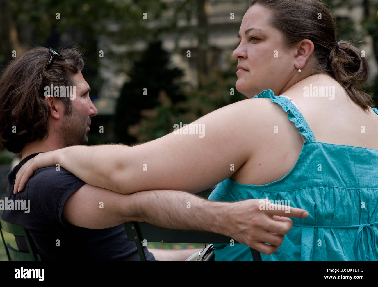 Un homme et une femme assis sur des chaises à Bryant Park à New York City semble être perdu dans ses pensées. Banque D'Images