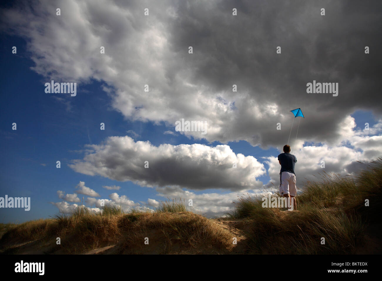Man flying kite on beach Banque D'Images