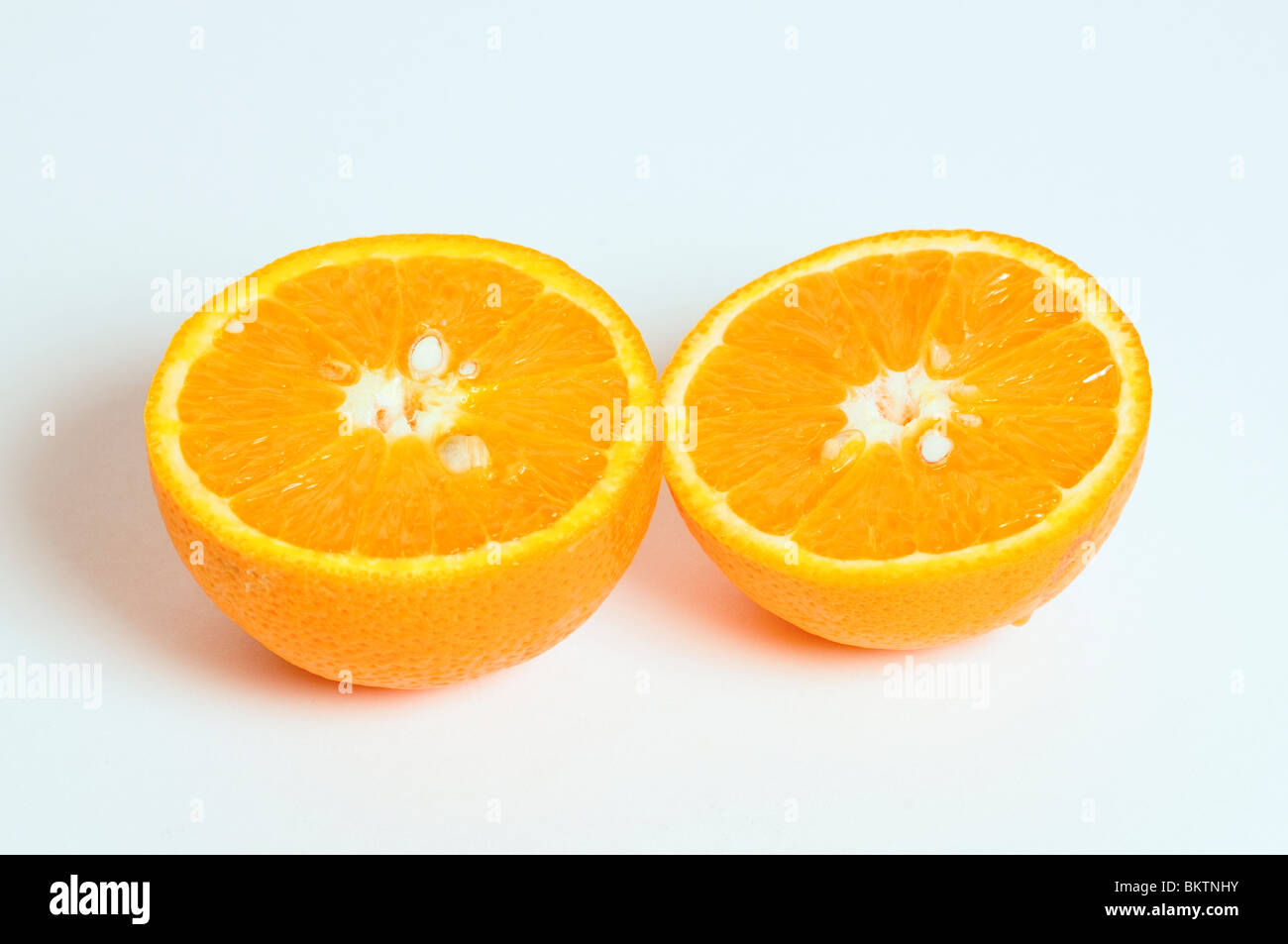 Réduire de moitié d'ORANGE SUR UN FOND BLANC Banque D'Images