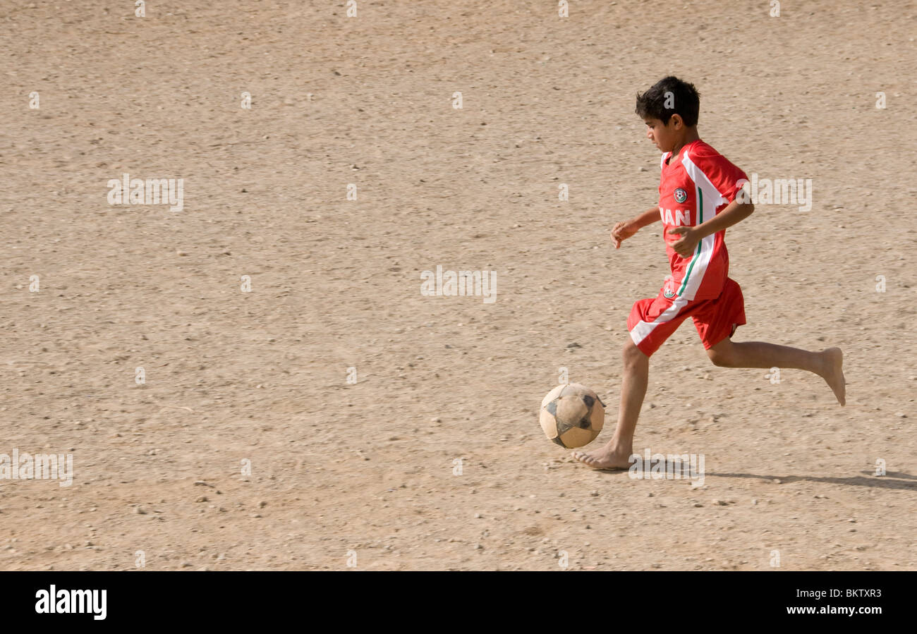 Enfant jouant au football Oman Banque D'Images