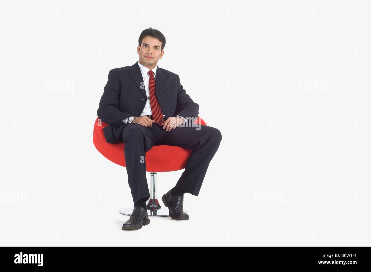 Young businessman sitting on swivel chair, portrait Banque D'Images