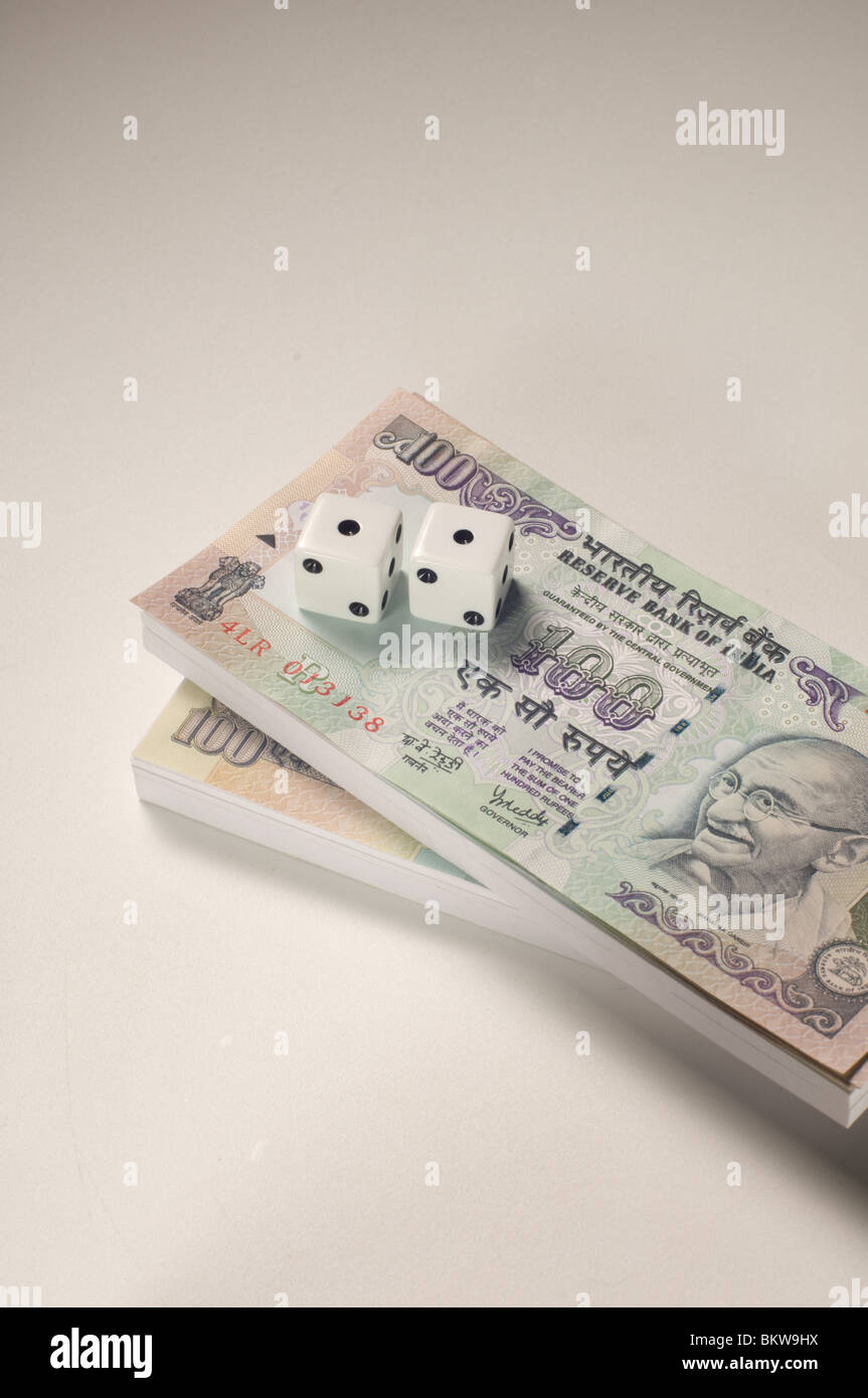 Deux dés sur le dessus de 100 billets de roupie indienne Banque D'Images