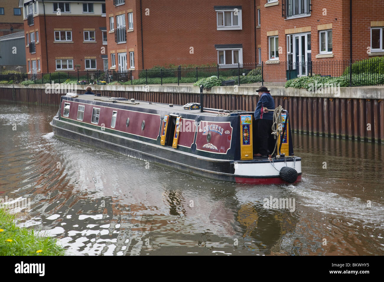 Un homme à la barre d'un bateau étroit sur le Grand Union canal, Loughborough, Leicestershire, Angleterre. Banque D'Images