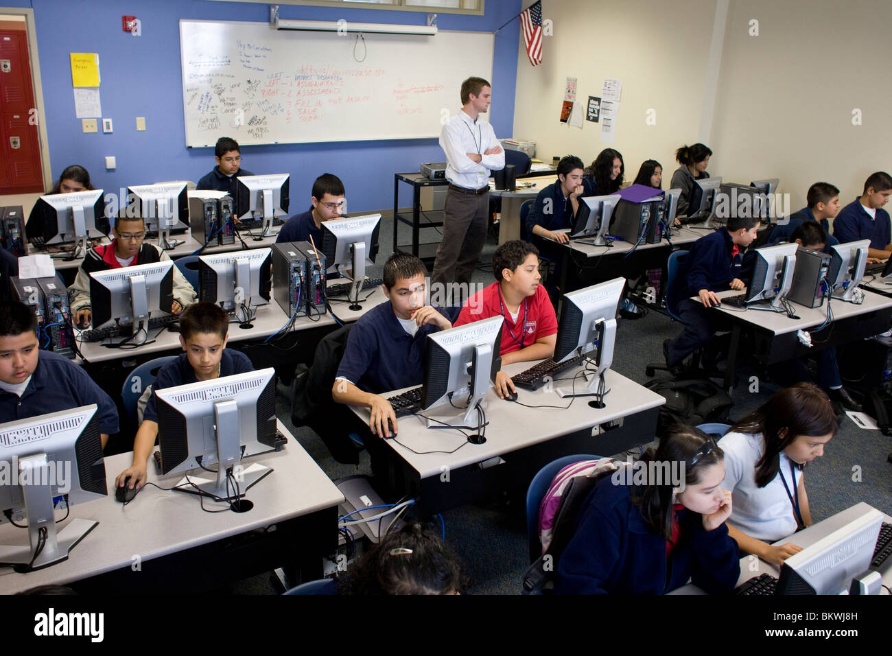 Enseignant surveille les élèves du secondaire dans le laboratoire informatique de l'école de charte Peak Preparatory Academy à Dallas, Texas, États-Unis. ©Bob Daemmrich Banque D'Images