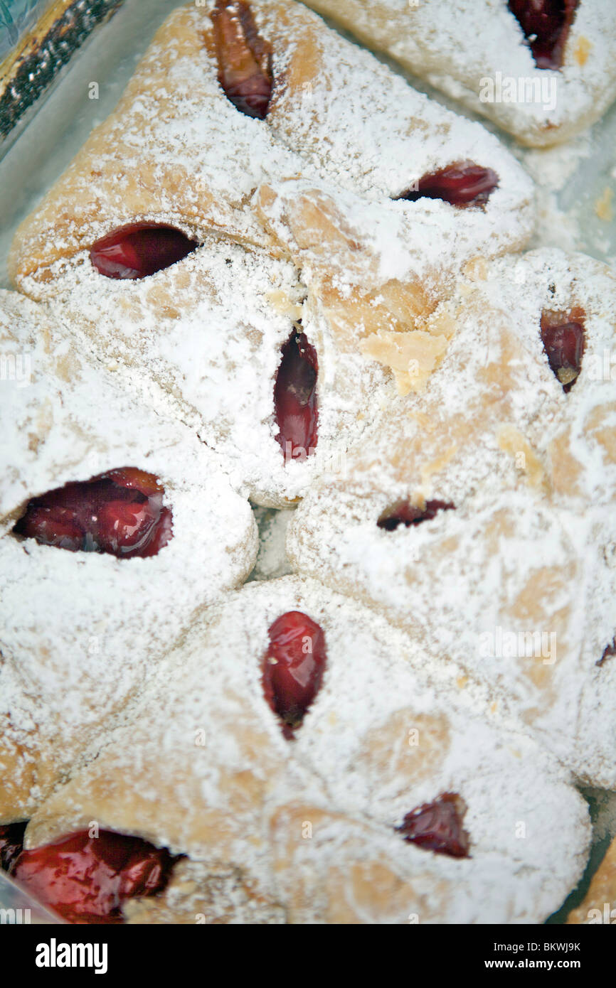 Chiffres d'cerise portant sur une plaque et saupoudrés de sucre glace. Banque D'Images