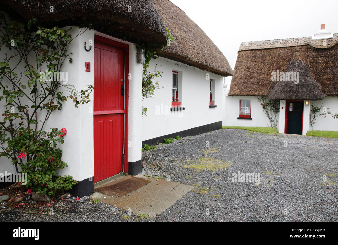 Chaumière traditionnelle avec porte rouge à Tully Cross dans le Connemara, Irlande Banque D'Images