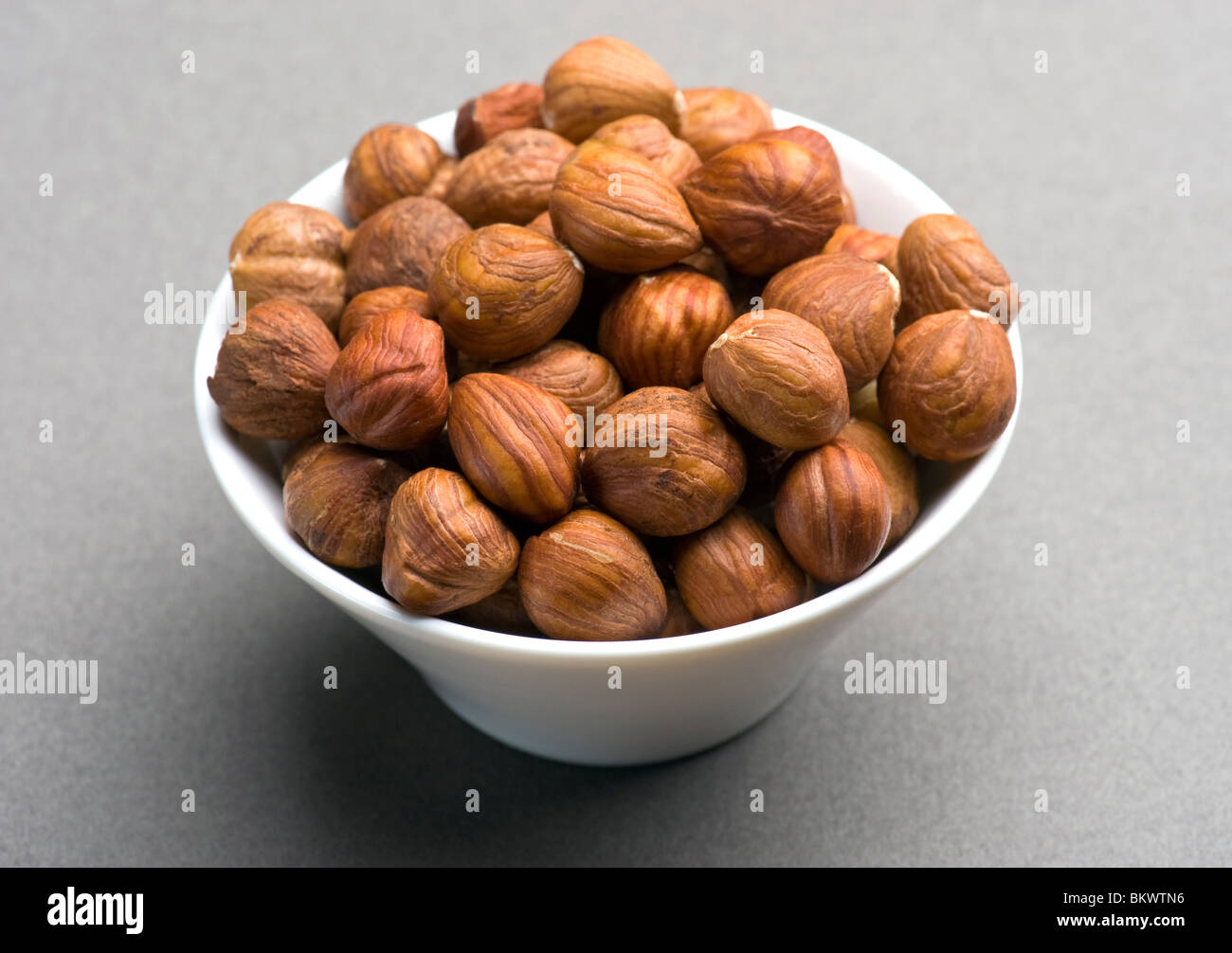 Les noisettes dans un plat blanc Banque D'Images
