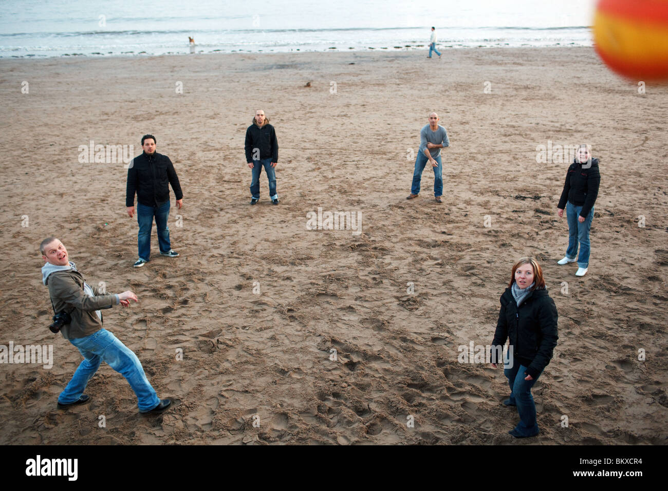 Les jeunes jouer au ballon sur la plage de Barry Island, près de Cardiff, au Royaume-Uni. Banque D'Images