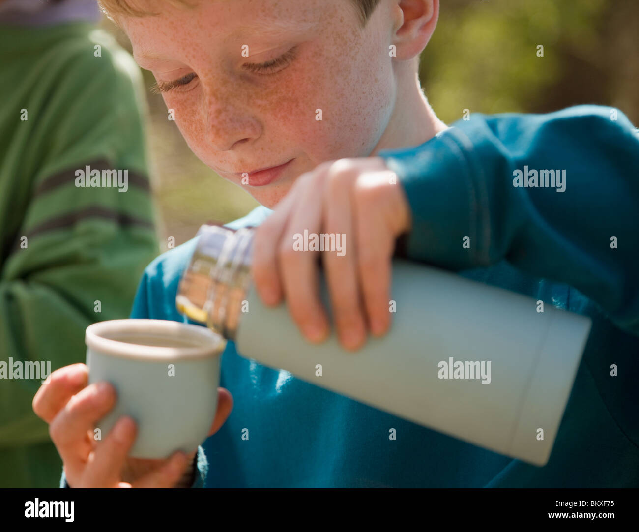 Close up of young boy verser de l'eau de ballon isolé Banque D'Images