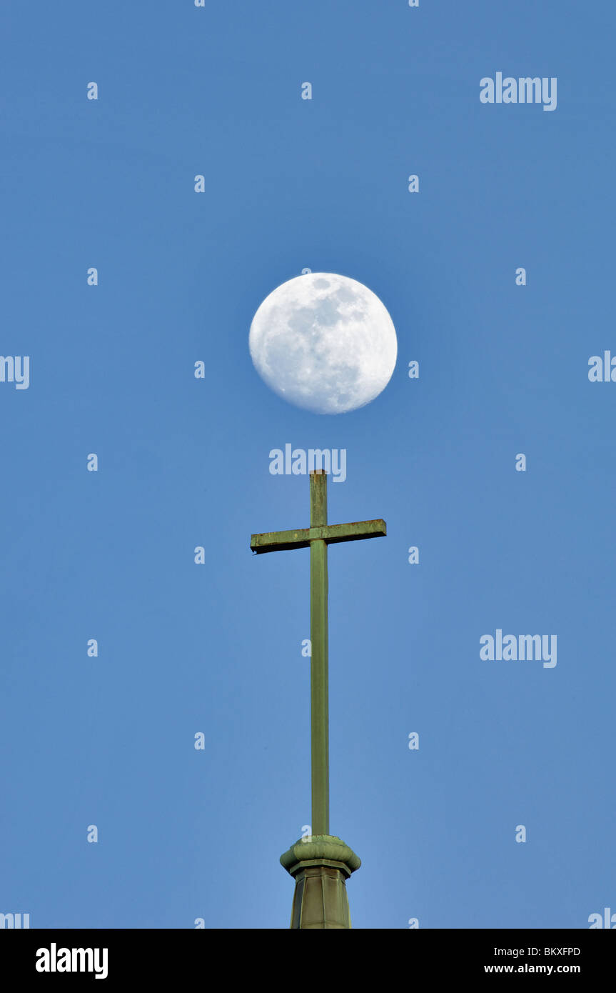 Croix chrétienne sur le dessus du clocher de l'Église avec lune derrière de Kannapolis, North Carolina Banque D'Images