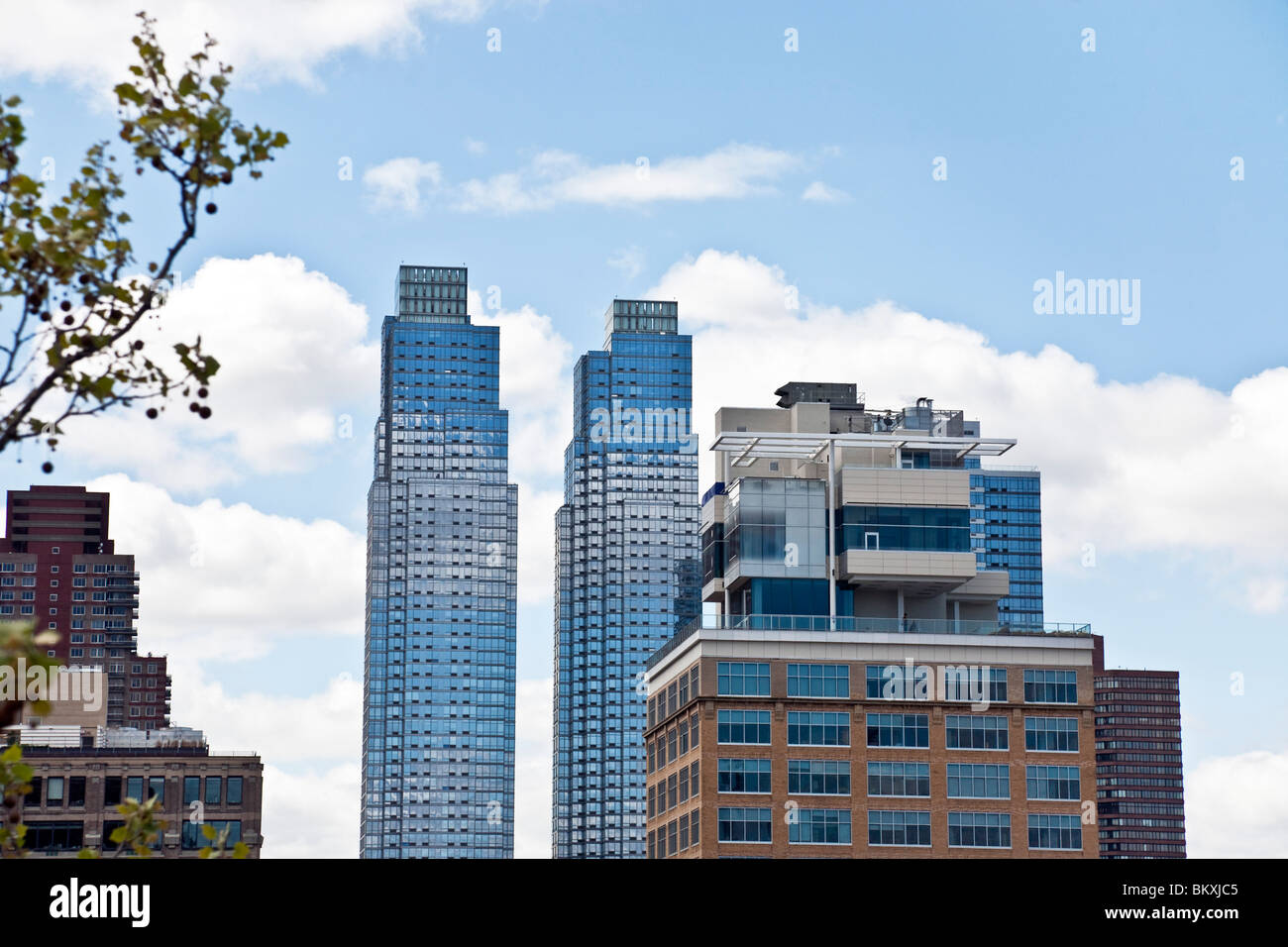 Appartement de Manhattan de verre reflètent les tours entourant ciel & nuages dans un curieux comme Magritte trompe-l'oeil à New York City Banque D'Images