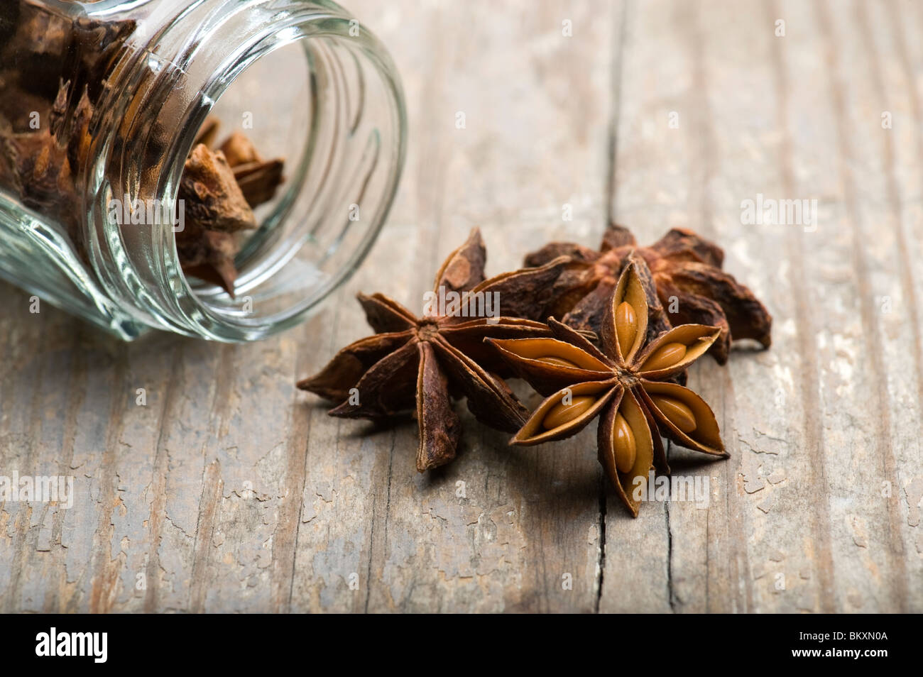 L'anis étoilé (Illicium verum) s'échappant du pot sur une table de cuisine en bois Banque D'Images