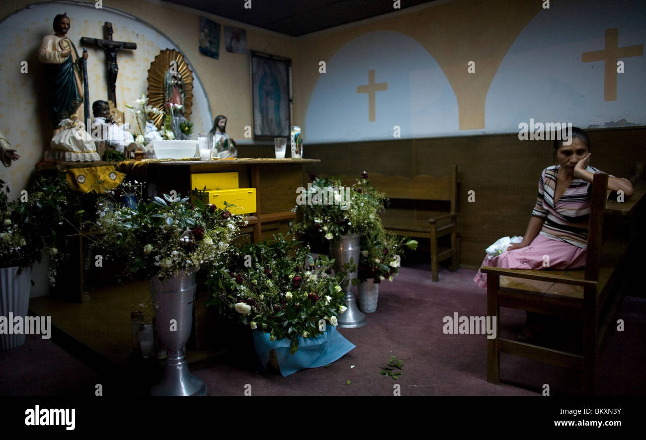 Une femme se tient dans la chapelle d'un refuge pour des enfants souffrant d'exécuter par le clou de fondation dans la ville de Mexico Banque D'Images Une femme se tient dans la chapelle d'un refuge pour des enfants souffrant d'exécuter par le clou de fondation dans la ville de Mexico Banque D'Images