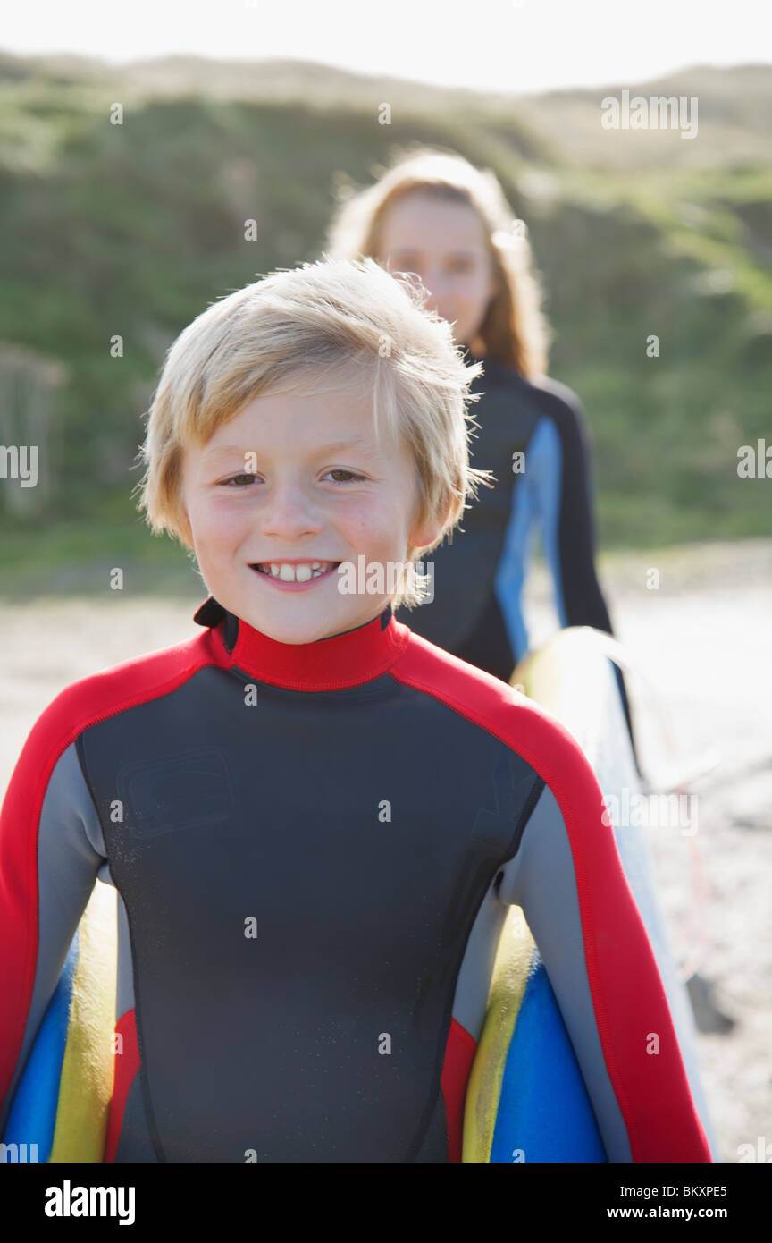 Close up of a smiling boy dans un port d'une combinaison de surf avec une fille Banque D'Images