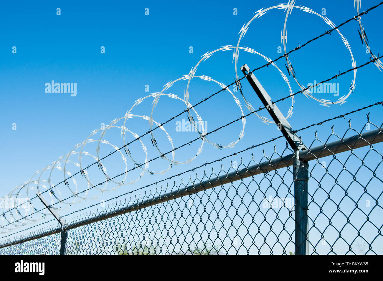 Fil de fer barbelé, de barbelés et de lien de la chaîne se combinent pour créer une barrière de sécurité. Banque D'Images