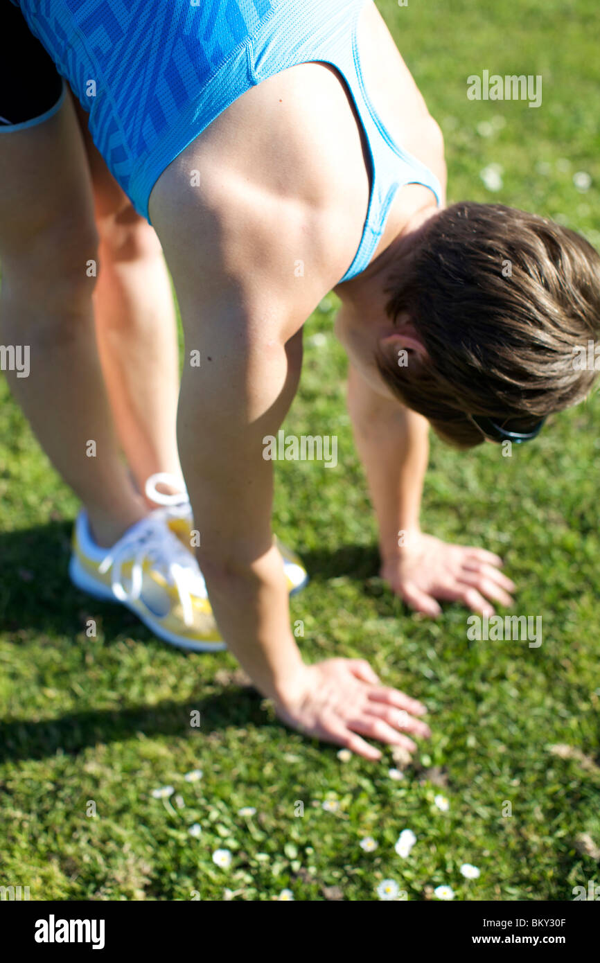 Femme à Coronado, Californie s'étend avant de commencer son exercice dans le parc sur une journée ensoleillée. Banque D'Images Femme à Coronado, Californie s'étend avant de commencer son exercice dans le parc sur une journée ensoleillée. Banque D'Images