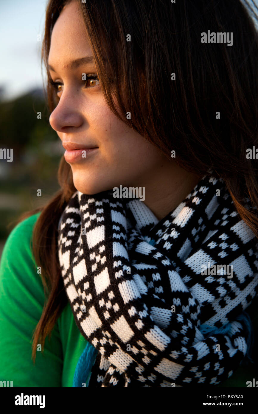 Close-up shot of young female wearing scarf en regardant le coucher du soleil. Banque D'Images