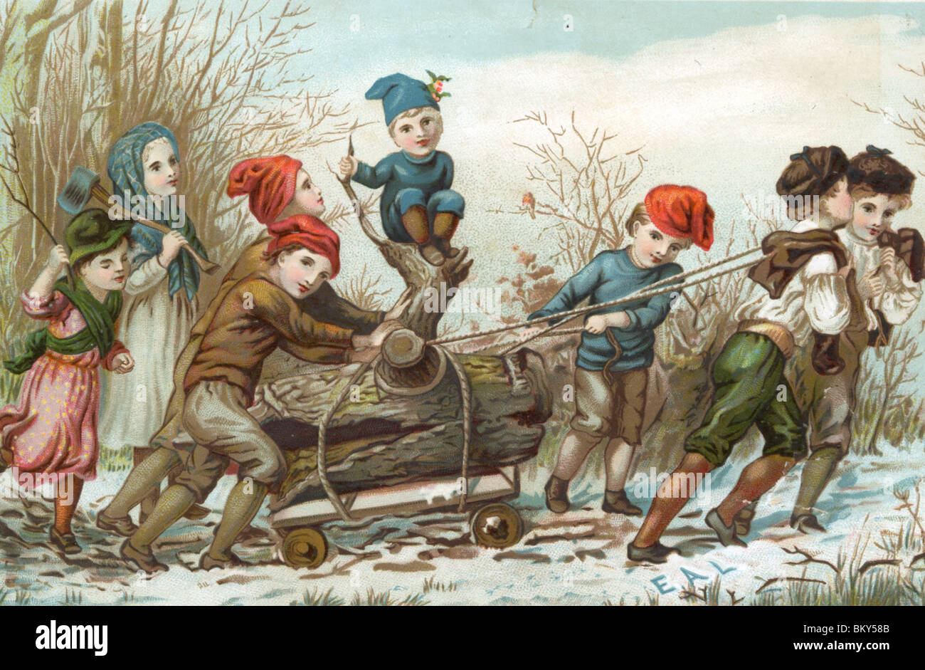 Les enfants tirant sur le tronc de l'arbre cassé en haut de la colline dans la neige Banque D'Images