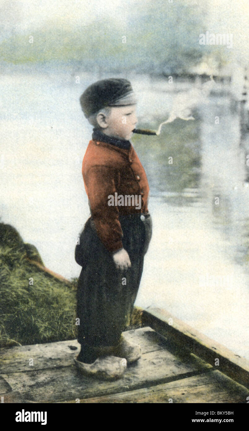 Jeune garçon fumant un cigare Banque D'Images