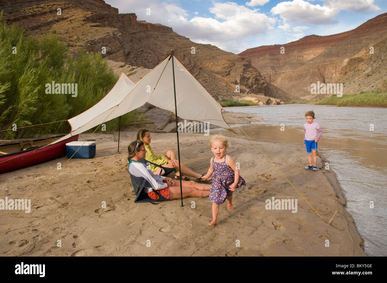 Deux jeunes filles jouant près de leur mère tout en camping sur la Rivière San Juan, Mexican Hat, Utah. Banque D'Images