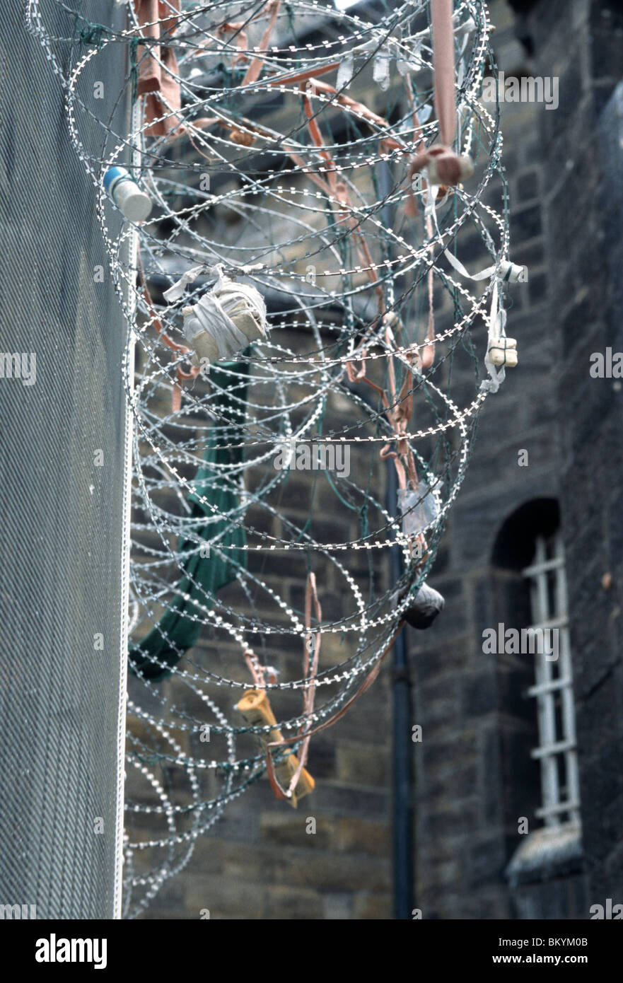 Clôture de barbelés, avec des paquets capturés dans il jeté fenêtres des cellules, à la prison de Leeds, Armley, Leeds, West Yorkshire, Royaume-Uni. Banque D'Images