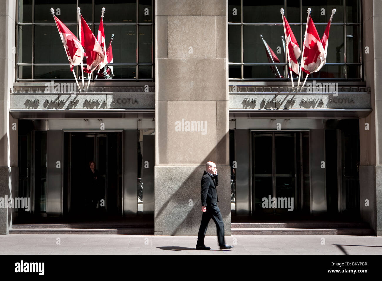 Un homme parle sur son téléphone cellulaire promenades par une banque de Nouvelle-Écosse bureaux à Toronto financial district Banque D'Images Un homme parle sur son téléphone cellulaire promenades par une banque de Nouvelle-Écosse bureaux à Toronto financial district Banque D'Images