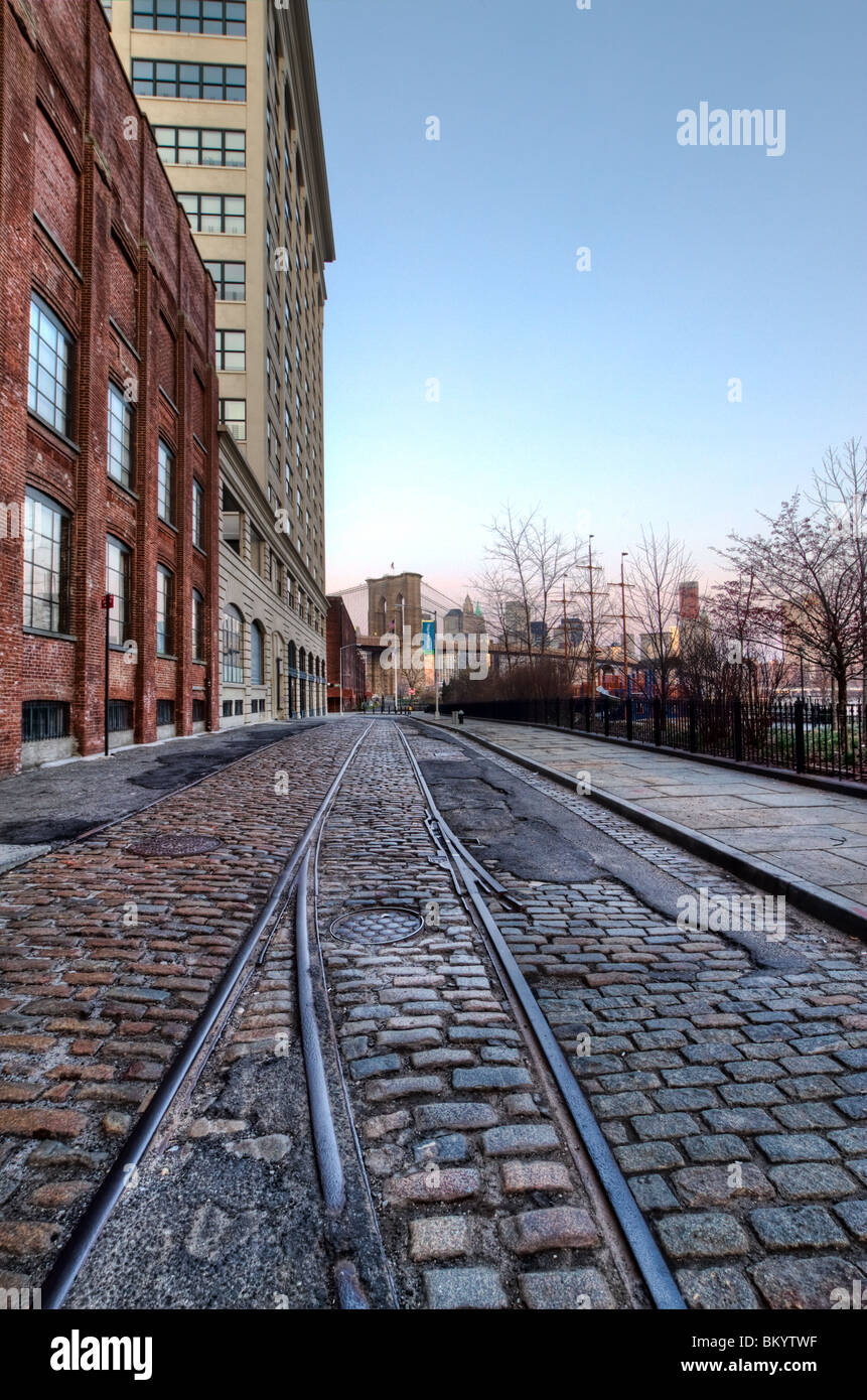 Bâtiments le long de la rue Plymouth couvertes pavées à l'aube. Le Pont de Brooklyn est vu dans l'arrière-plan. Banque D'Images