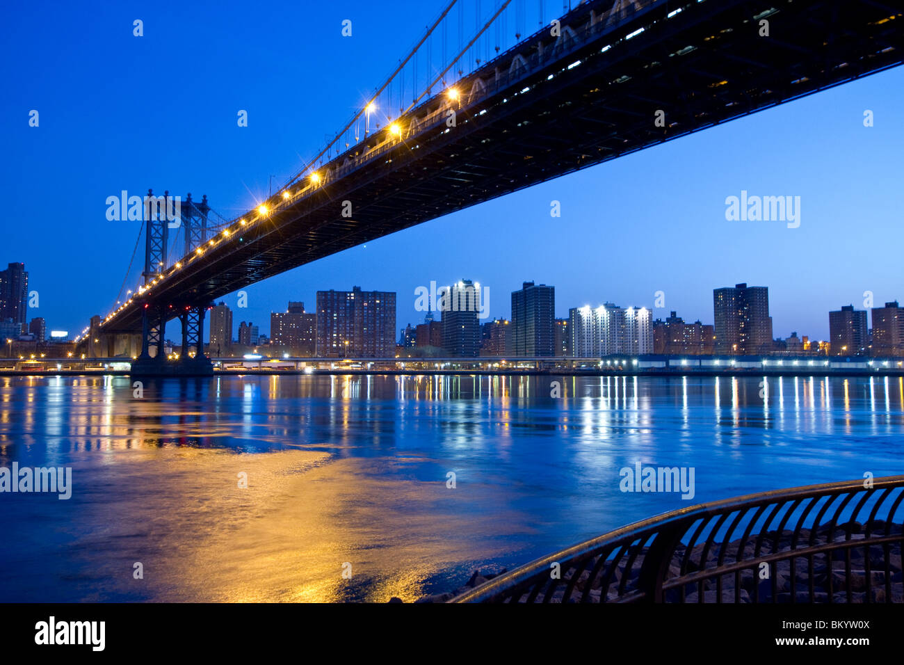 Le Manhattan Bridge enjambant l'East River à l'horizon de Manhattan en arrière-plan vu du pont de Brooklyn par la nuit Banque D'Images