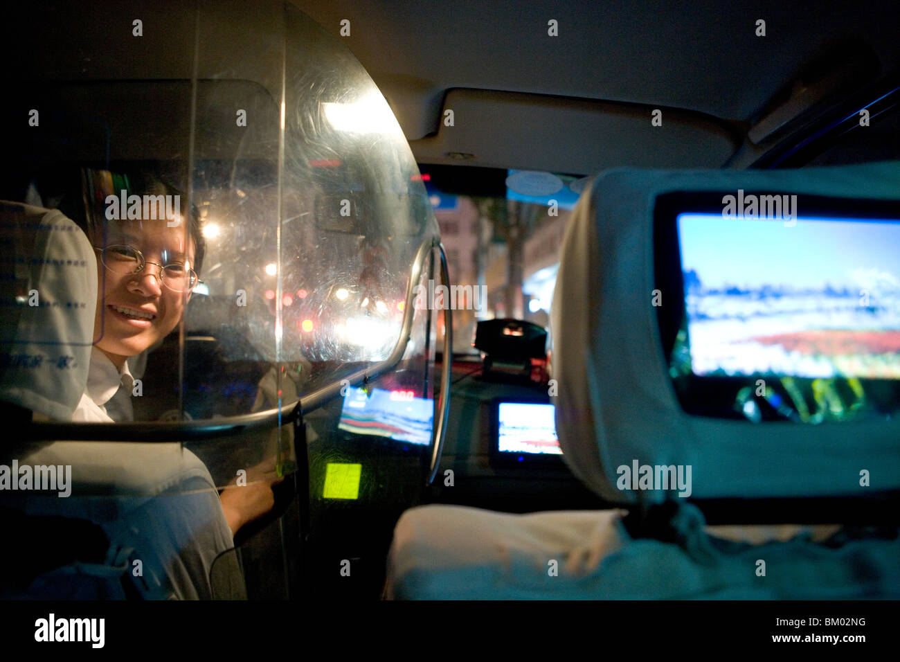 Shanghai Taxi, femme chauffeur de taxi, un bouclier de protection, écran de télévision, heureux, riant, heureux, le bonheur Banque D'Images