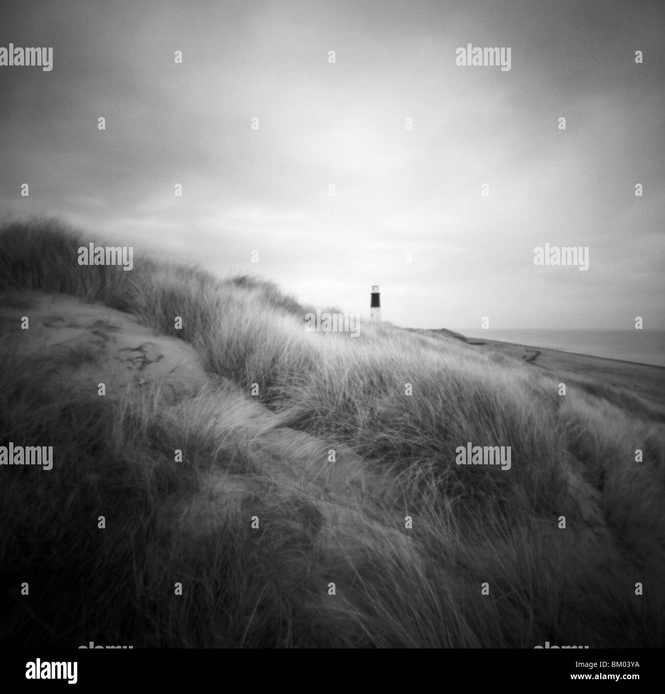 Seule figure sur le sable au bord de la tête de traiter avec mépris les banques Point Lighthouse, East Yorkshire, Angleterre Banque D'Images