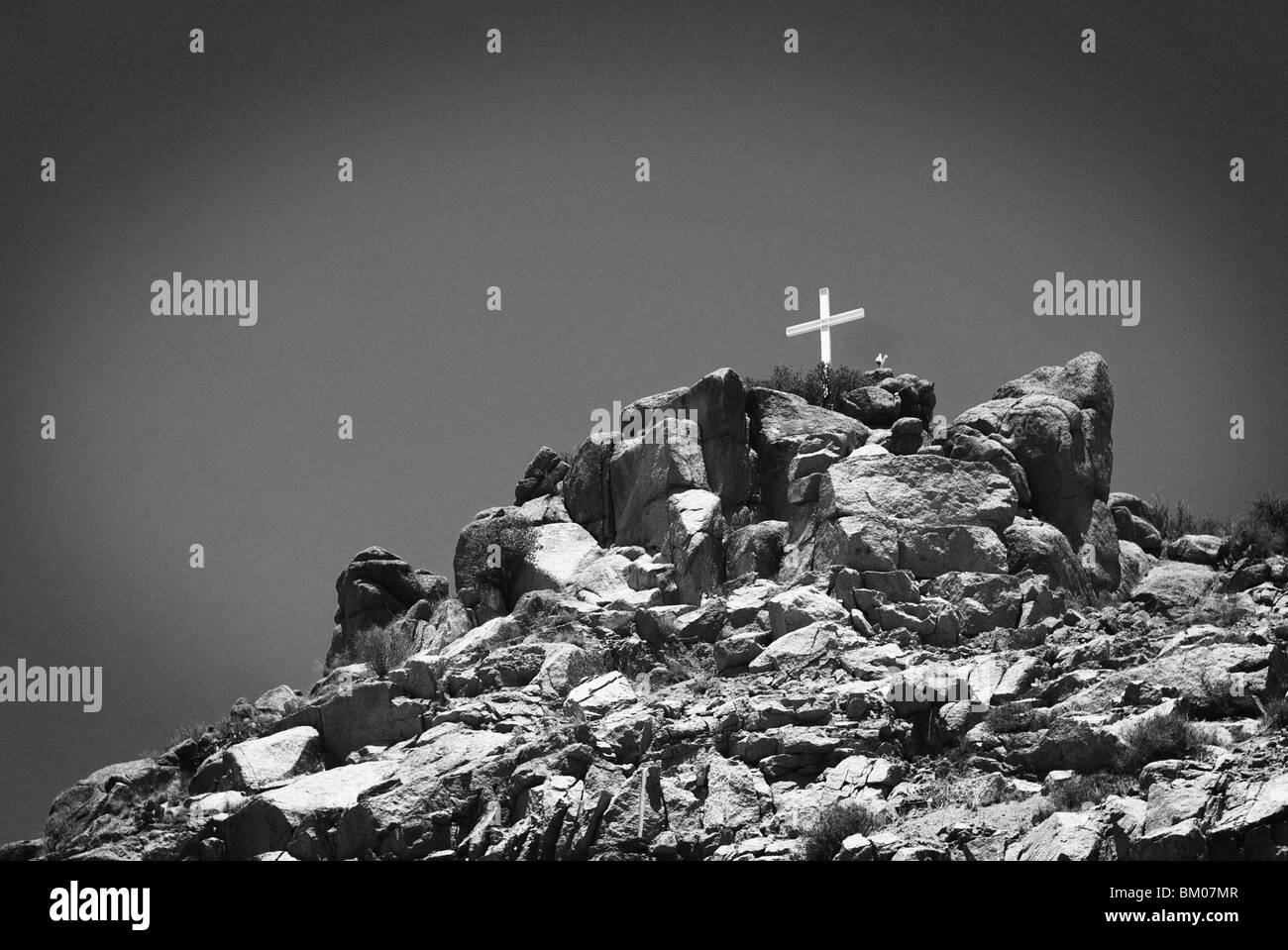 Cross se trouve au sommet d'une montagne de Sandia boulder mound paysage en noir et blanc, le long de la route 66, Albuquerque, Nouveau Mexique Banque D'Images