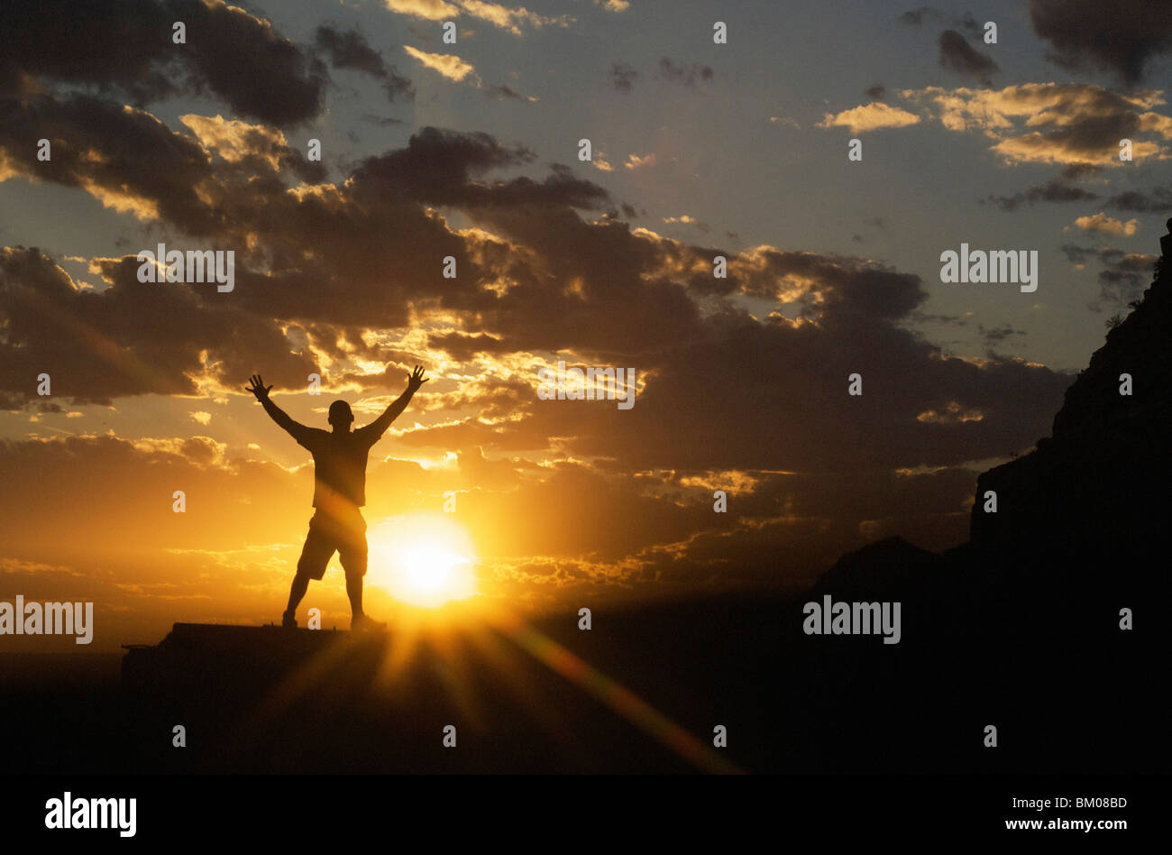 Paysages et nature des concepts d'inspiration : silhouette of man célébrant le ciel coucher de soleil spectaculaire standing arms diffusion large Banque D'Images