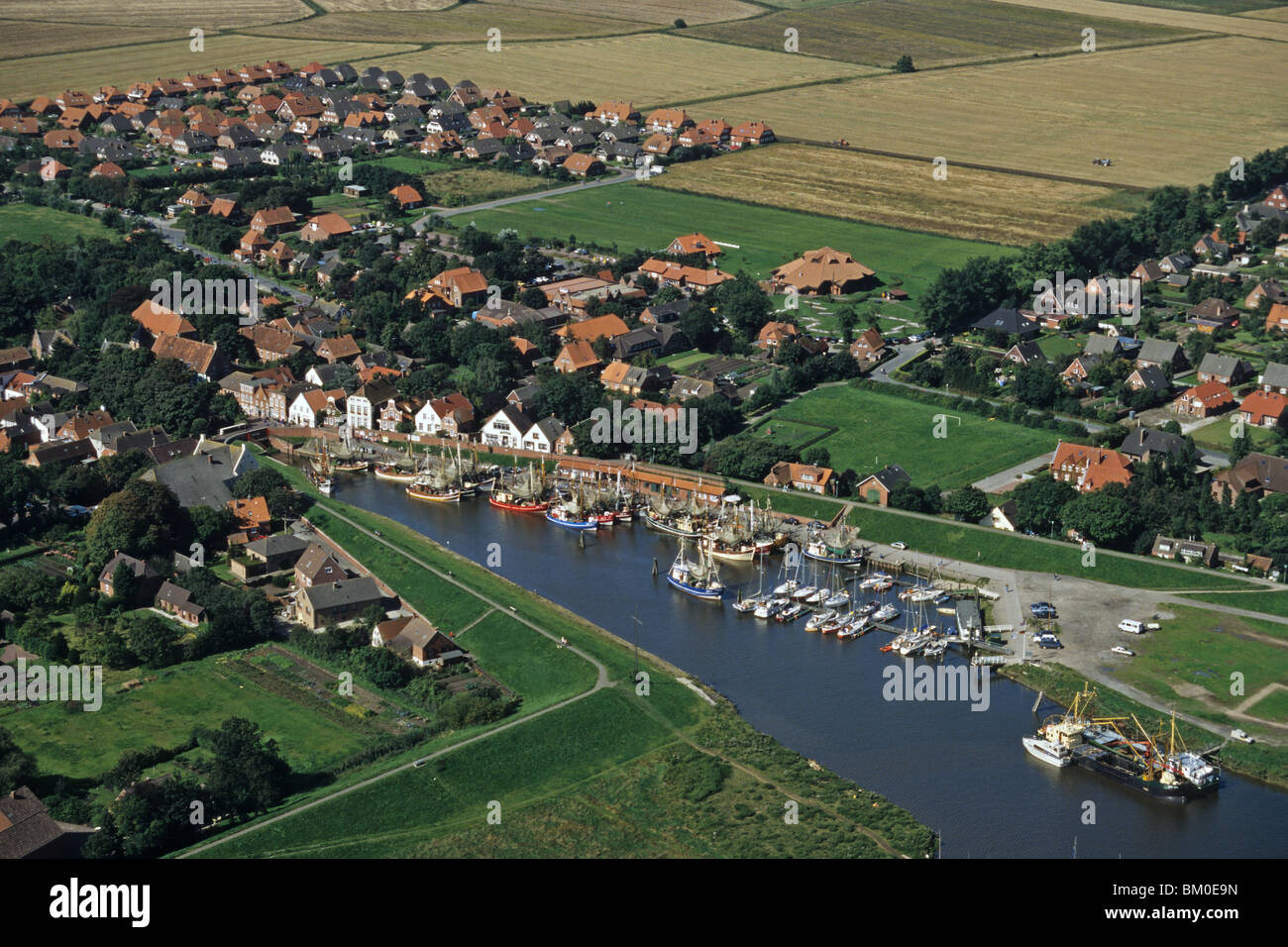 Photo aérienne du petit port de Greetsiel sur la rivière Leybucht en Frise orientale, bateaux de crevettes, Basse-Saxe, Allemagne du nord Banque D'Images
