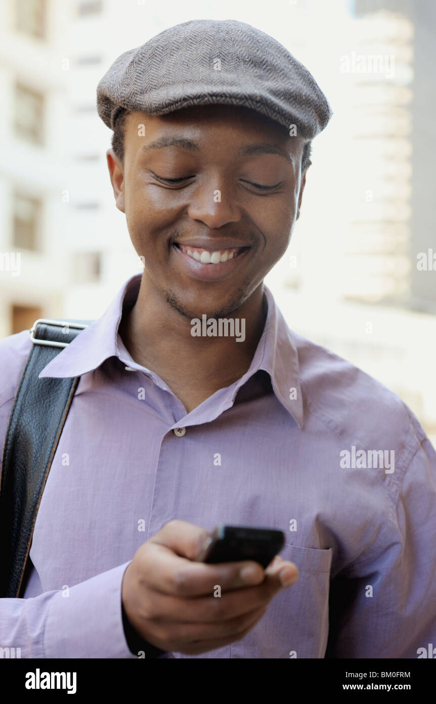 Jeune homme de la lecture de texte Message, Cape Town, Western Cape Province, Afrique du Sud Banque D'Images