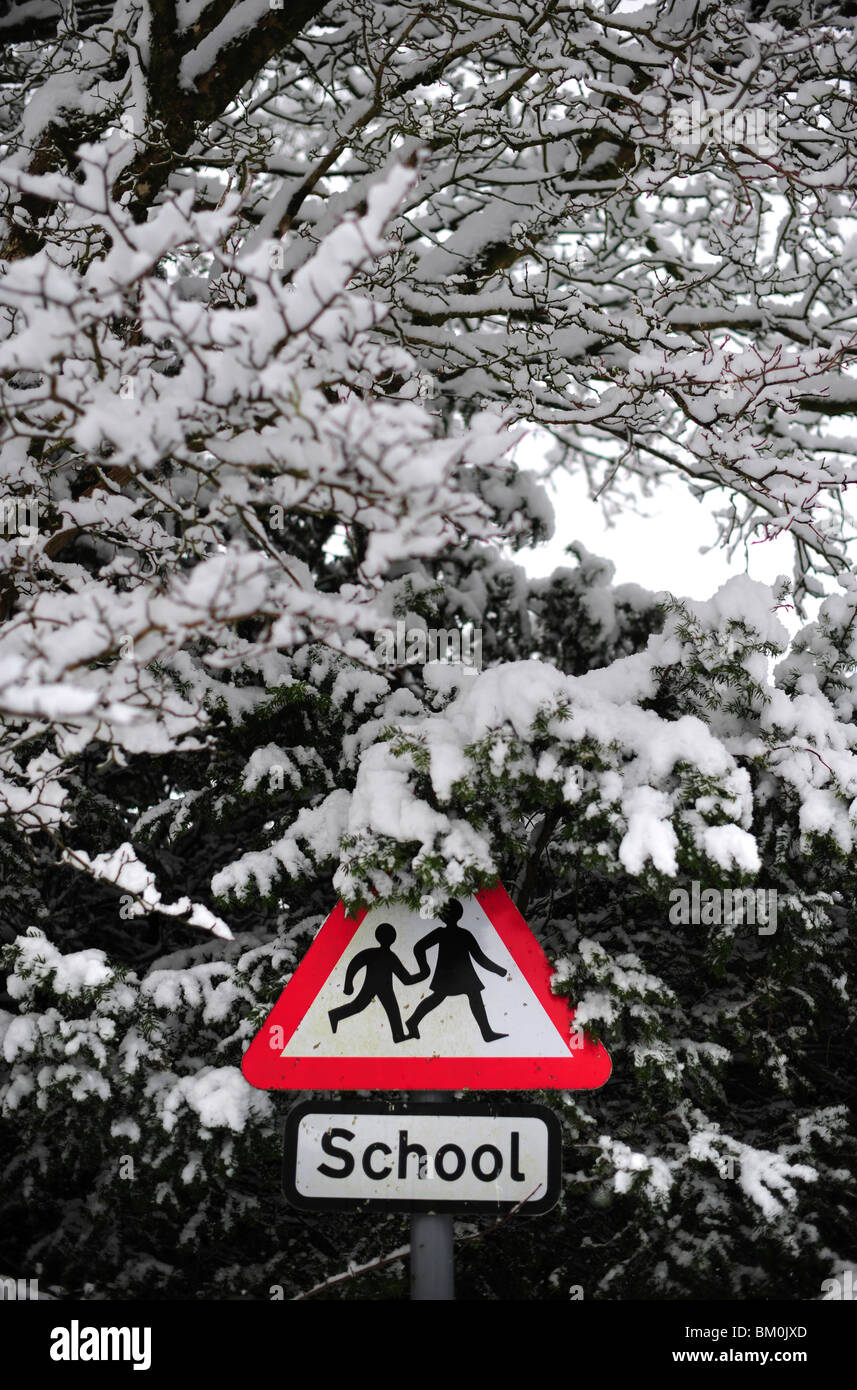 Un signe de l'école couvert autour de la neige, illustrant les écoles étant fermées au cours de la neige lourde et profonde Banque D'Images