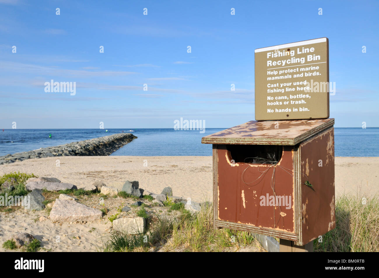Ligne de pêche en bois avec bac de recyclage signe en plage par jetty à Sandwich, Cape Cod-NOUS Banque D'Images