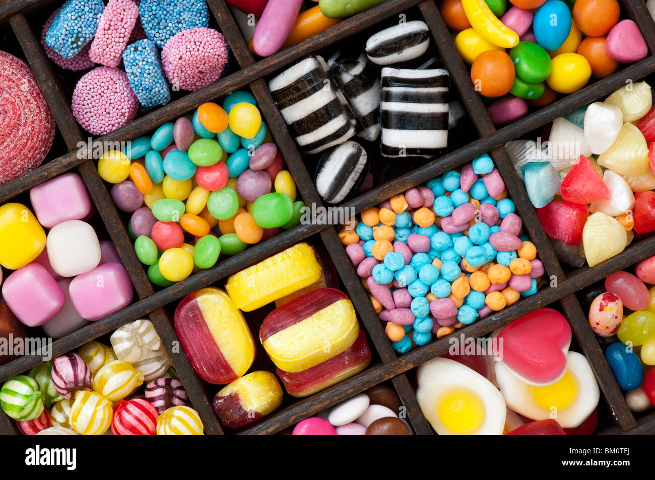 Assortiment de bonbons colorés pour enfants et des bonbons dans un plateau en bois Banque D'Images