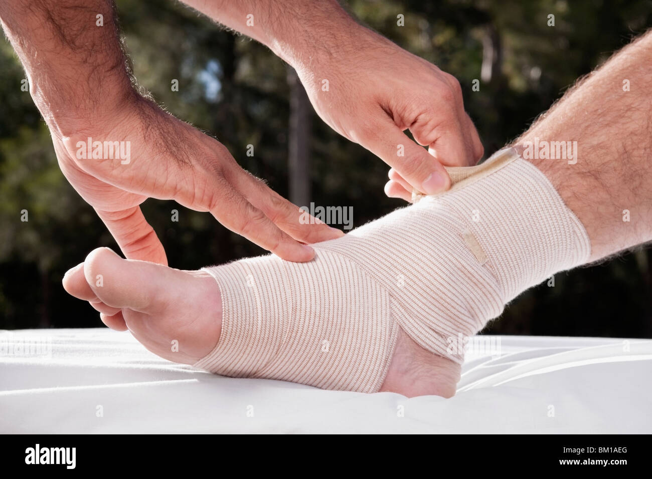Crêpe de liage médecin bandage sur un pied du patient Photo Stock - Alamy