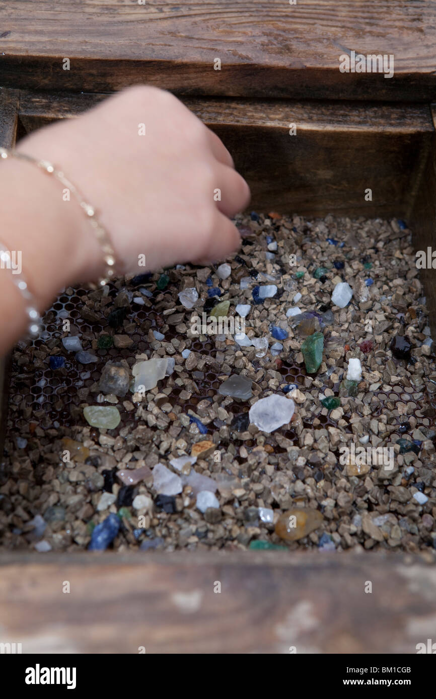 L'enfant part à la recherche de pierres dans le sable Banque D'Images
